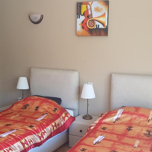 a bedroom with two beds and a picture on the wall at Luxury Flat Marina Agadir in Agadir