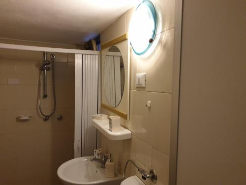 een badkamer met een wastafel en een spiegel bij Santa Maria Di Leuca Villa Etta in Gagliano del Capo