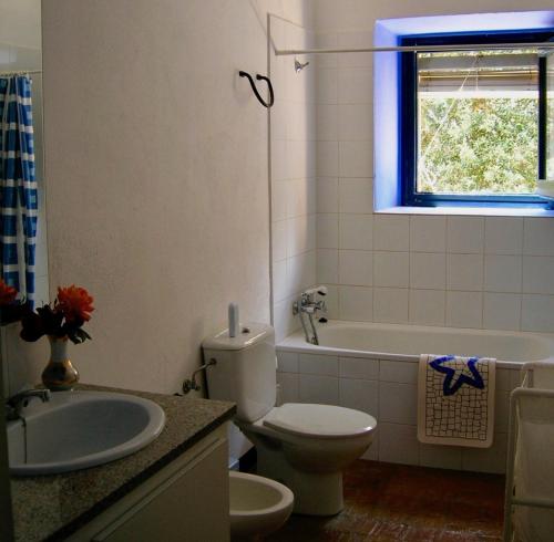 y baño con aseo, bañera y lavamanos. en Can Guilló 1, en Darnius