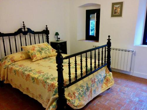 1 dormitorio con 1 cama con colcha de flores en Can Guilló 1, en Darnius