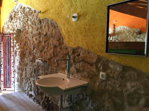 a bathroom with a sink and a stone wall at Spiti Anne in Makrádes
