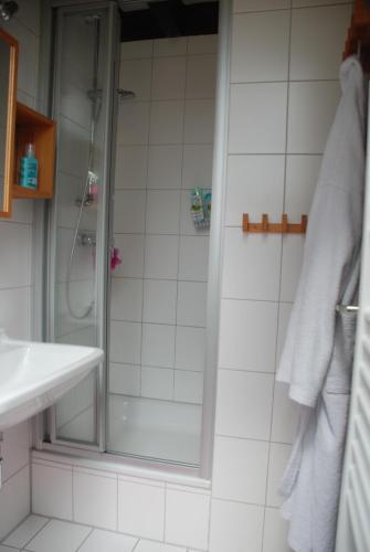 uma casa de banho com um chuveiro e um lavatório. em Eifelwolke em Kerschenbach