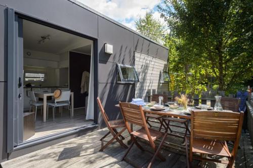 une terrasse avec une table et des chaises ainsi qu'une maison dans l'établissement Rives Nature, à La Gacilly