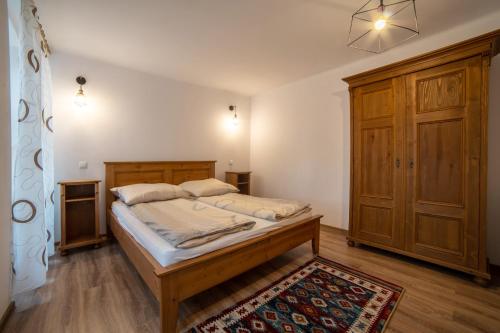 a bedroom with a bed and a wooden cabinet at Gloria Apartments in Sighişoara