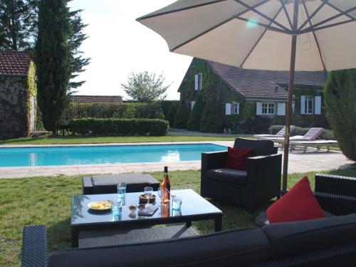 une table et des chaises avec un parasol à côté d'une piscine dans l'établissement Mansion in Charrin by Loire with Pool, à Charrin