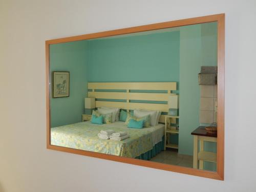 a mirror reflection of a bed in a bedroom at Palmina Mare Villa and Studios in Paralia Vrachou