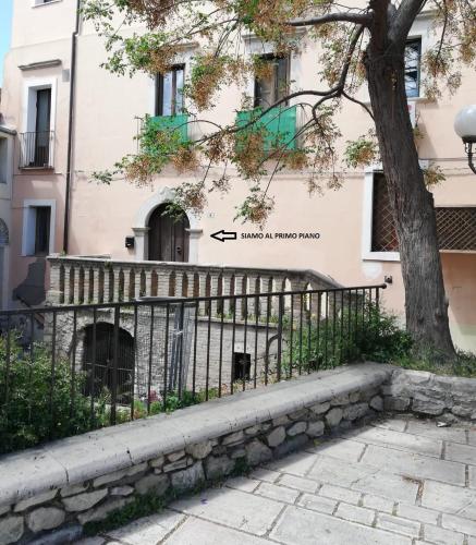 a fence in front of a building with a tree at Valerio's Home Historical Center in Larino