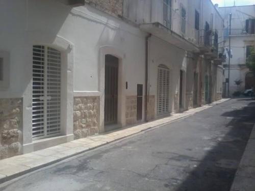 an empty street next to a white building at Casa Vacanze Giovanni Cesare in Noci