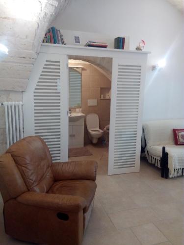 a living room with a couch and a bed and a chair at Casa Vacanze Giovanni Cesare in Noci
