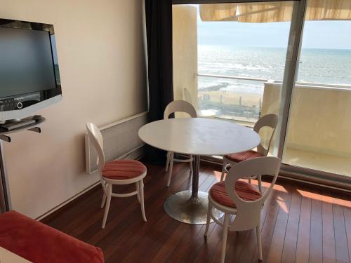 a room with a table and chairs and a window at Studio Face Ocean in Lacanau