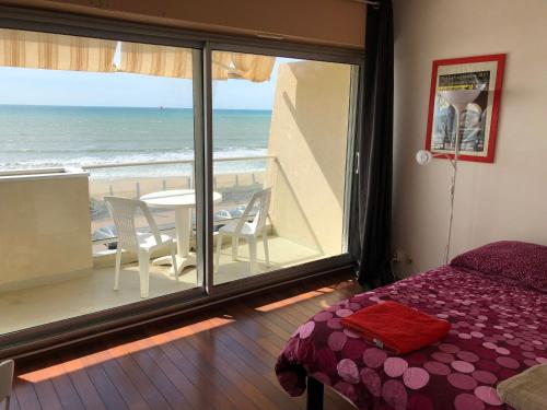 a bedroom with a view of the ocean from a balcony at Studio Face Ocean in Lacanau