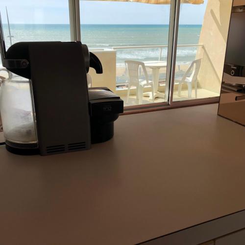 a hair dryer on a counter with a view of the ocean at Studio Face Ocean in Lacanau