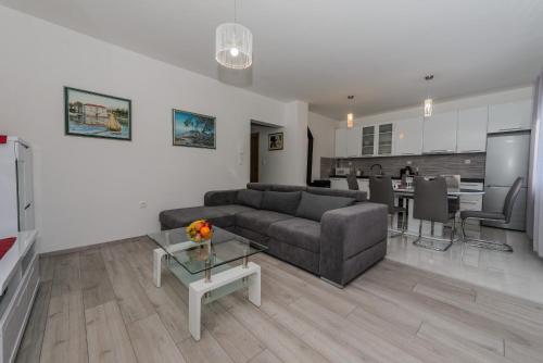 - un salon avec un canapé et une table dans l'établissement Apartments Basic, à Kaštela