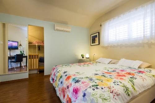 1 dormitorio con 1 cama grande con colcha de flores en Homey suite in Zichron Yaakov en Zikhron Ya‘aqov