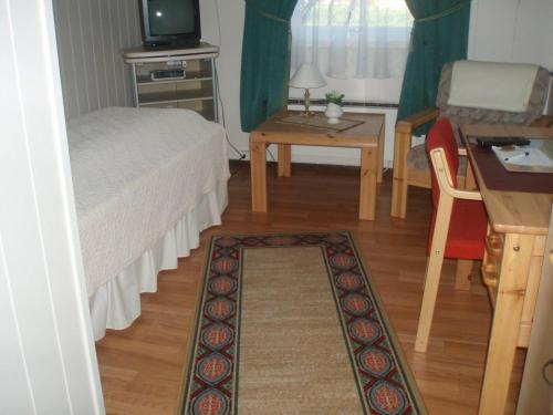 Schlafzimmer mit einem Bett, einem Tisch und einem Schreibtisch in der Unterkunft Vadsø Apartment in Vadsø