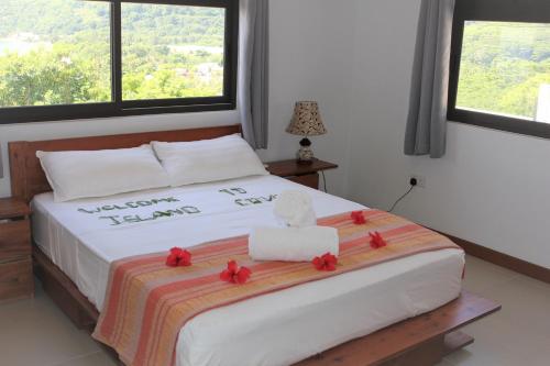 una camera da letto con un letto con fiori rossi di Island Cove a Victoria