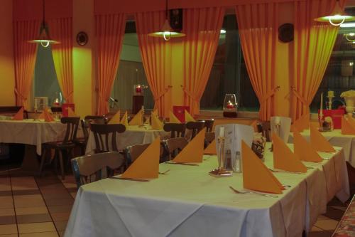 a row of tables in a restaurant with orange curtains at TOTO's Gasthaus in Hattingen
