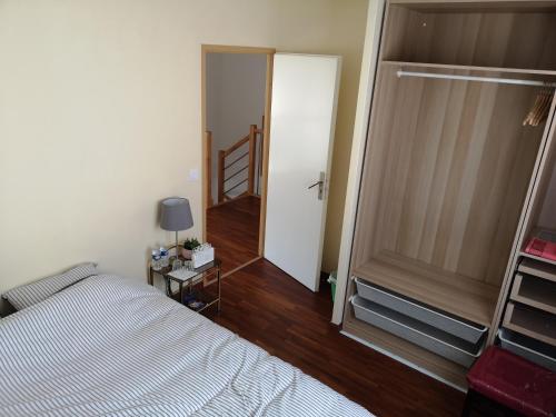 ein Schlafzimmer mit einem Bett und einer Tür zu einem Flur in der Unterkunft bienvenus chez Éric à Montévrain in Montévrain