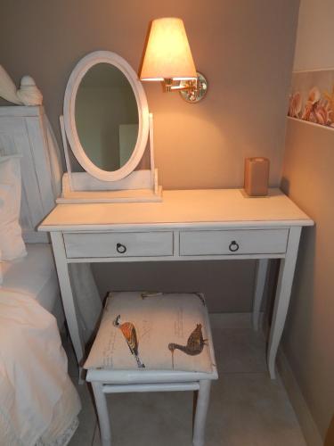 a white dressing table with a mirror and a stool at Palmina Mare Villa and Studios in Paralia Vrachou