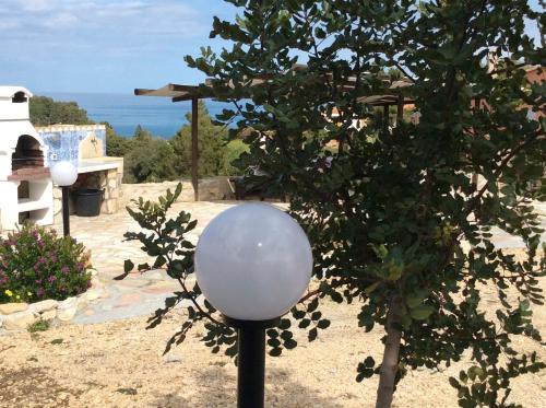 a street light sitting next to a tree at Scopello Guidaloca Villas in Scopello