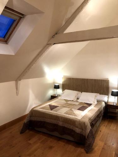 une chambre avec un grand lit dans un grenier dans l'établissement Les Gîtes de Roz-Maria, à Quintin