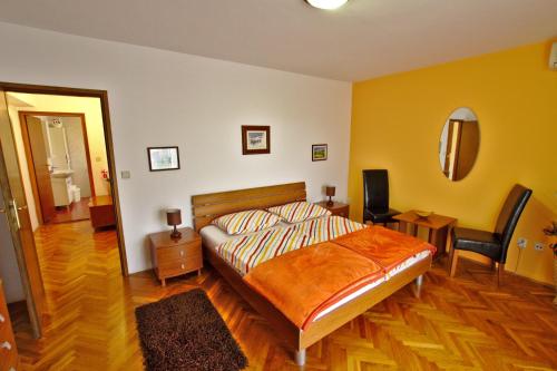 a bedroom with a bed and a chair and a mirror at Apartments and Rooms Irena in Rovinj
