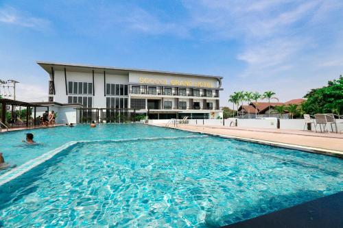 a large swimming pool in front of a building at Socool Grand Hotel in Nang Rong