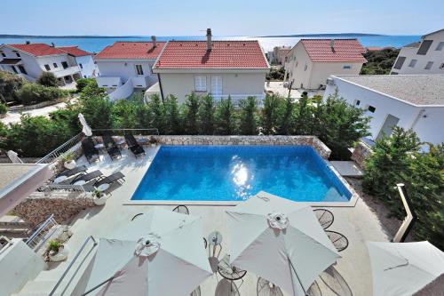 una piscina con sombrillas en un patio en Deluxe Villa No.10 - Rooms & Apartments, en Mandre
