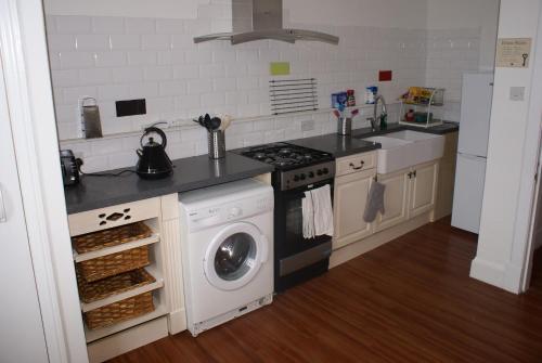 a kitchen with a stove and a washing machine at Mid Flat in Dumfries