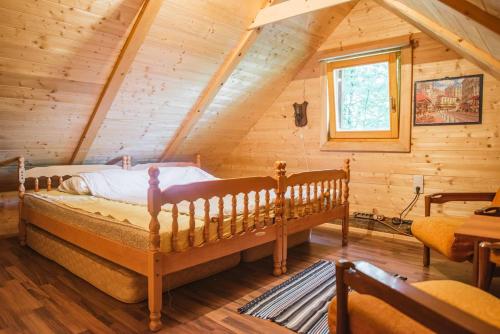 una camera con un letto in una baita di tronchi di WOODEN HOUSE near the River Kupa a Kamanje