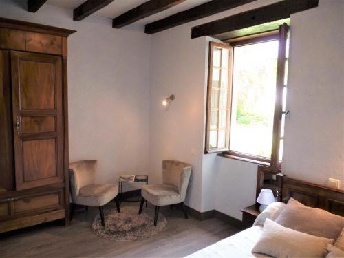 une chambre avec un lit et deux chaises et une fenêtre dans l'établissement Chambre d'hôtes Altzia 1, à Saint-Michel