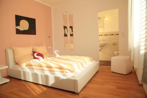a white bed in a room with a bathroom at Ferienhaus Viktoria in Abfaltersbach