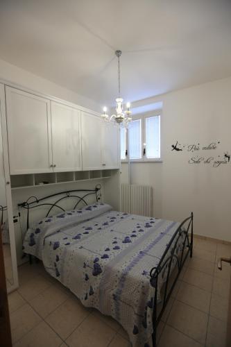 um quarto com uma cama, armários brancos e um lustre em Casa Trilli em Grottammare