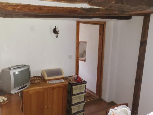 a room with a tv on a dresser with a telephone at Дядовата къща in Tryavna