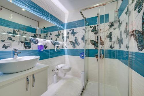 y baño con aseo, lavabo y ducha. en Mersin Vip House Hotel en Mersin