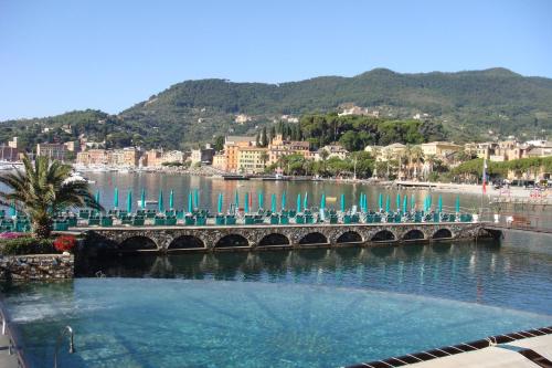 a bridge over a body of water with chairs at Hotel Helios in Santa Margherita Ligure