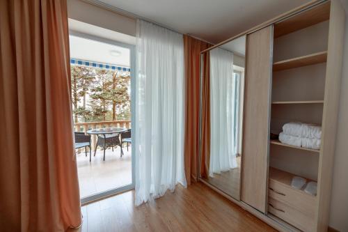 Habitación con puerta corredera de cristal que da a un patio. en Kolkhida Resort & Spa, en Ureki
