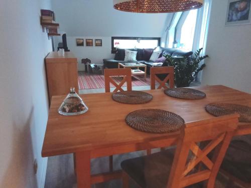 een houten eettafel met stoelen en een woonkamer bij Pier 213 in Bad Zwischenahn