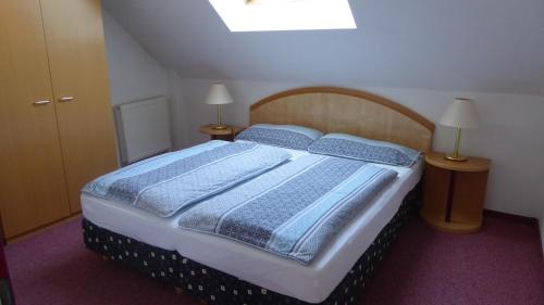 a bedroom with a bed with two blue pillows at Thermen Chalet 85m² in Lutzmannsburg