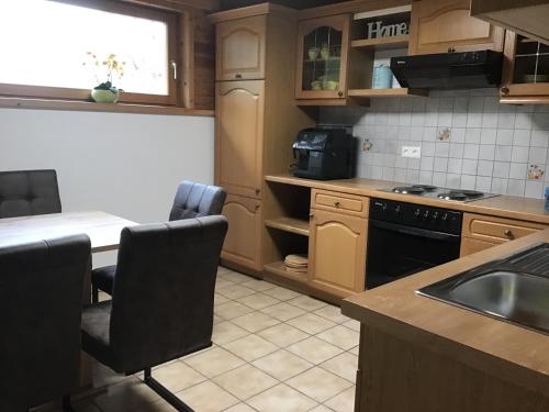 a kitchen with a sink and a table with chairs at Haus Manuela in Velden am Wörthersee