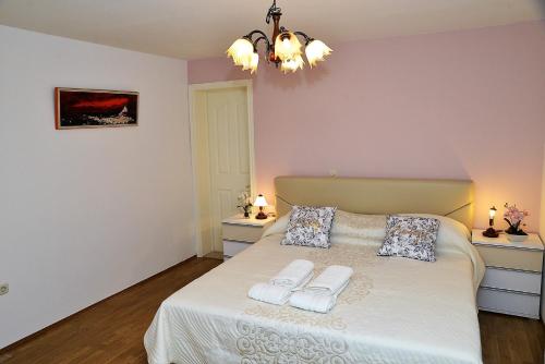 a bedroom with a bed with two towels on it at Apartments Anamarija in Makarska