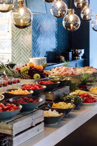 a buffet with many bowls of fruits and vegetables at Amerikalinjen in Oslo