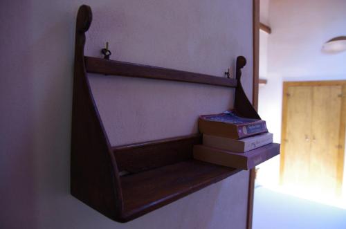 a book shelf with books on a wall at Podere Pinzicalari in Castel del Piano