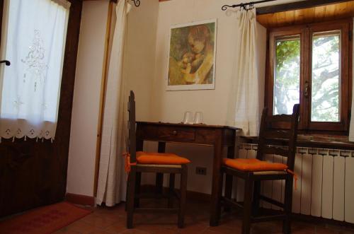 a room with two chairs and a desk and a window at Podere Pinzicalari in Castel del Piano