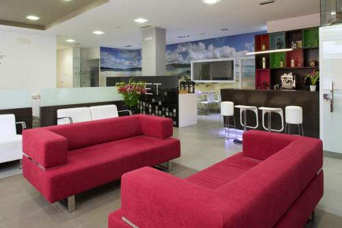 a living room with two red couches and chairs at Hotel Vila da Guarda in A Guarda