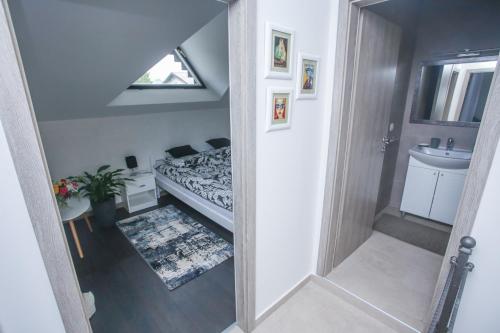 ein Badezimmer mit einem Bett, einem Waschbecken und einem Spiegel in der Unterkunft Apartman ART in Bihać