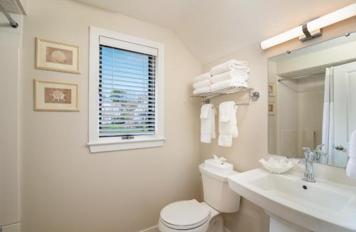 a bathroom with a toilet and a sink and a window at The Club at New Seabury in Mashpee