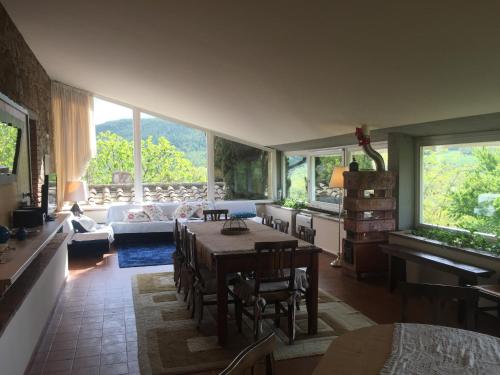 a living room with a table and chairs and windows at La Vittoria 10 – La Soglia della Val d’Orcia in Chianciano Terme