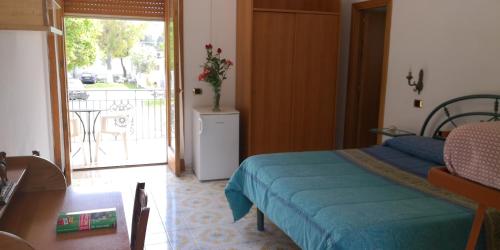 sypialnia z łóżkiem i drzwiami prowadzącymi na balkon w obiekcie Villaggio "Camping Pompei" w mieście Pompeje