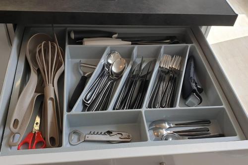 un tiroir rempli d'ustensiles de cuisine dans une cuisine dans l'établissement joli studio calme coeur de ville, à Nancy